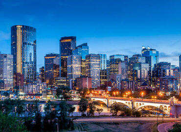 Calgary skyline at night with Bow River and Centre Street Bridge.